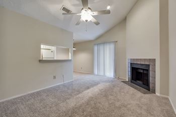 A living room with a fireplace and a ceiling fan.